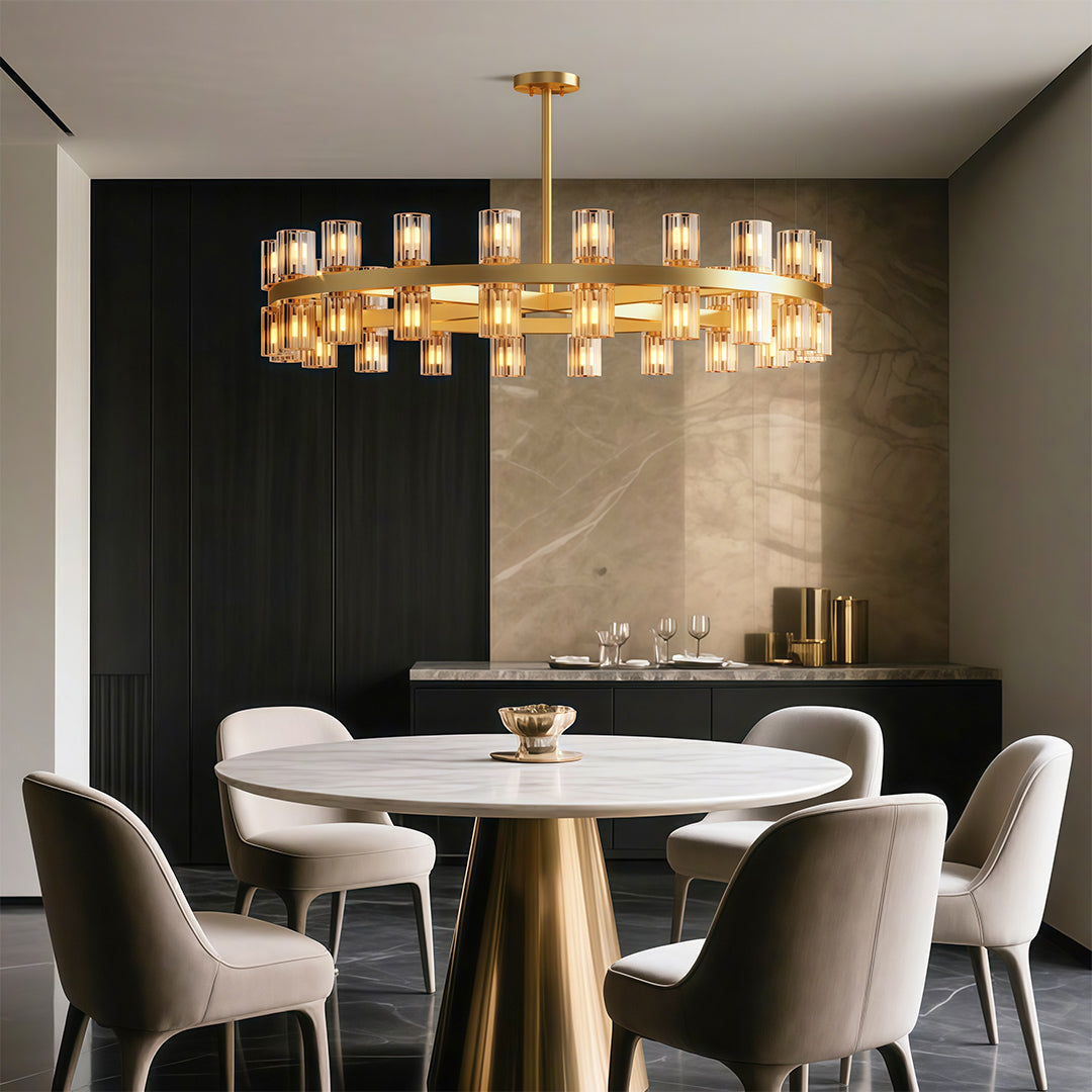 Round brass chandelier with glass shades above a white round dining table and cream chairs