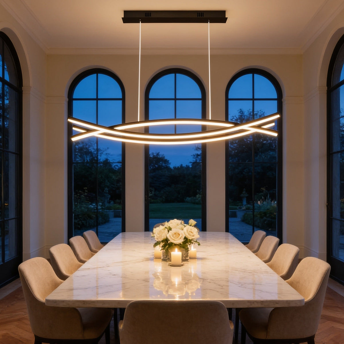 Crossing lines of warm light above a long marble dining table with flowers and candles, beneath tall arched windows at dusk