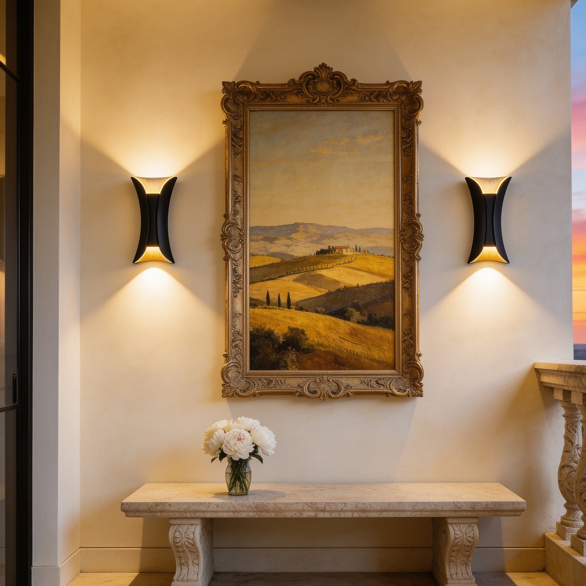 Pair of Curved Up and Down Wall Lights beside a gilt framed landscape painting