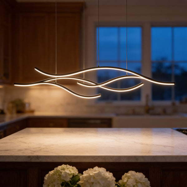 Curved Wave Pendant Light glowing over a marble kitchen island