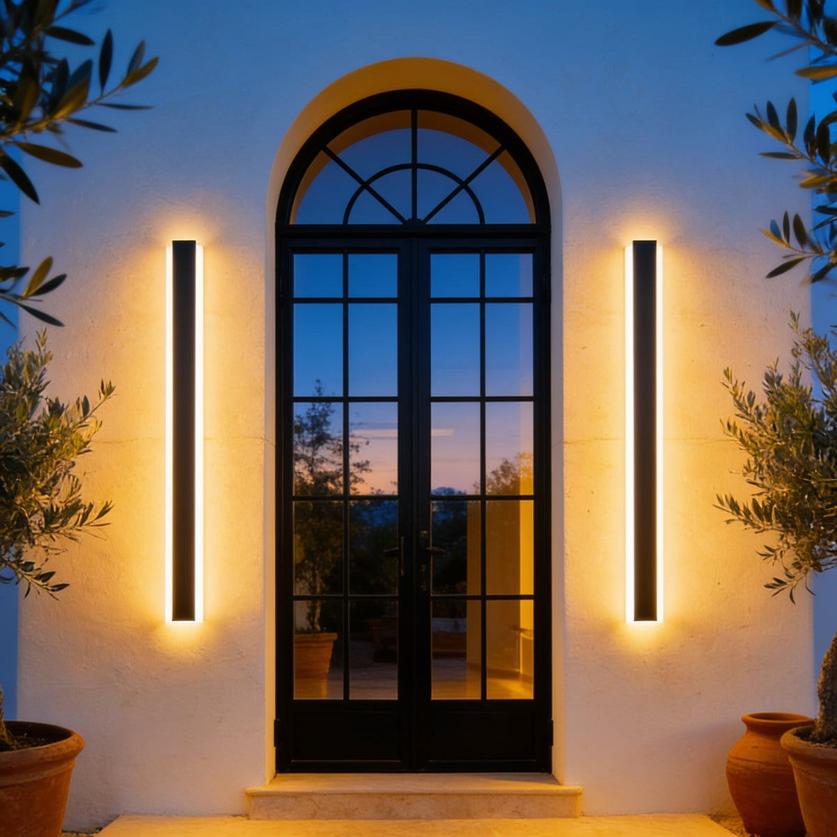 Two Gate Wall Lights beside an arched black door on a white villa