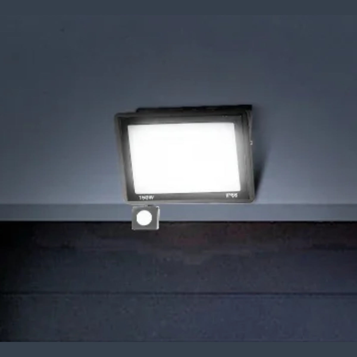LED motion sensor floodlight lighting a garage door at night