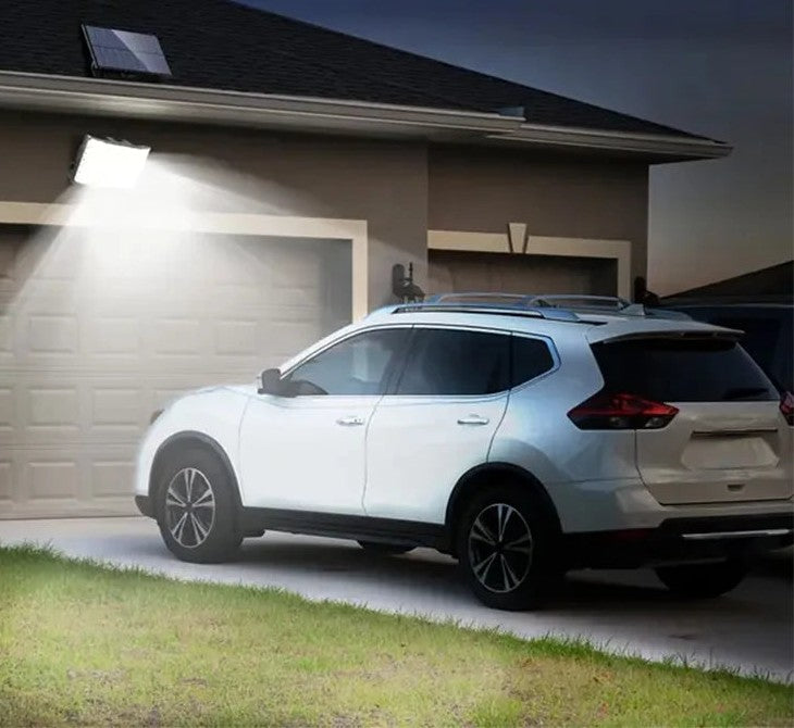 Solar powered motion sensor flood light lighting a garage at night