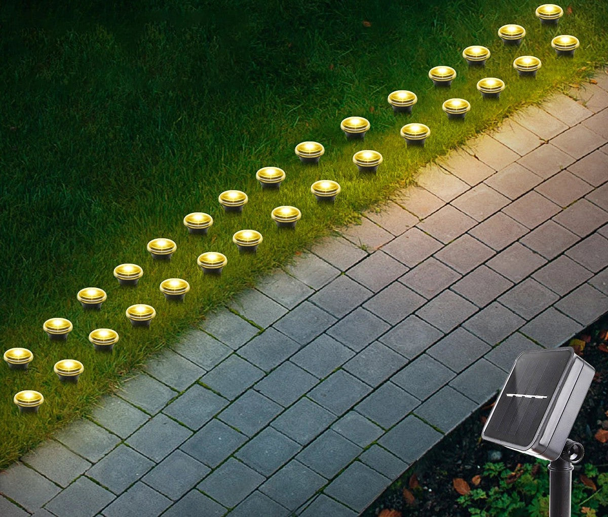 Warm white solar pathway lights along a paver walkway