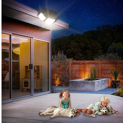 Solar flood light lighting a patio with children and dogs