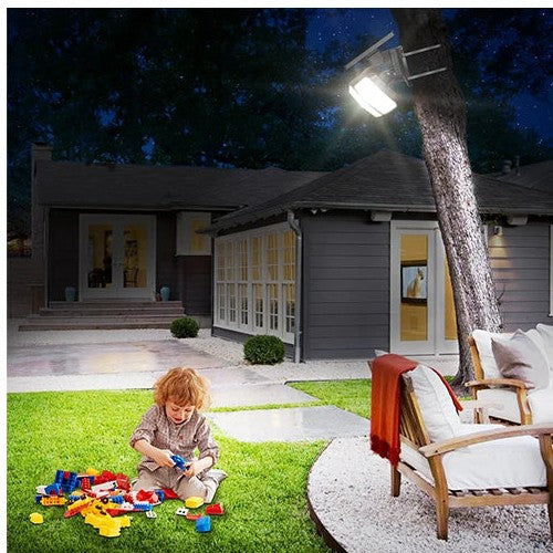 Solar flood light lighting a front lawn with a child playing