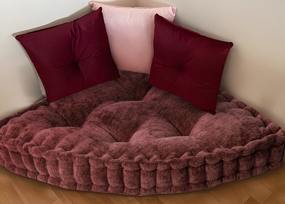 Quarter round chenille floor cushion in a corner with throw pillows