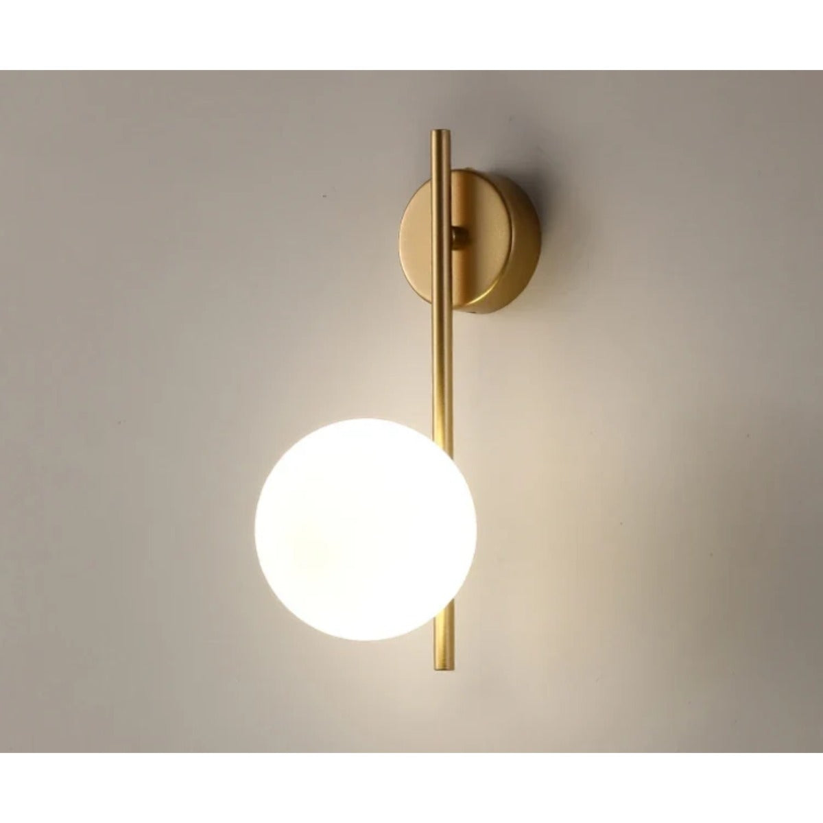 Gold glass globe wall lamp lit