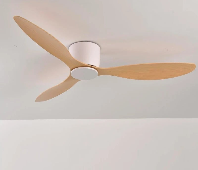 Low profile ceiling fan with light wood blades on a white ceiling