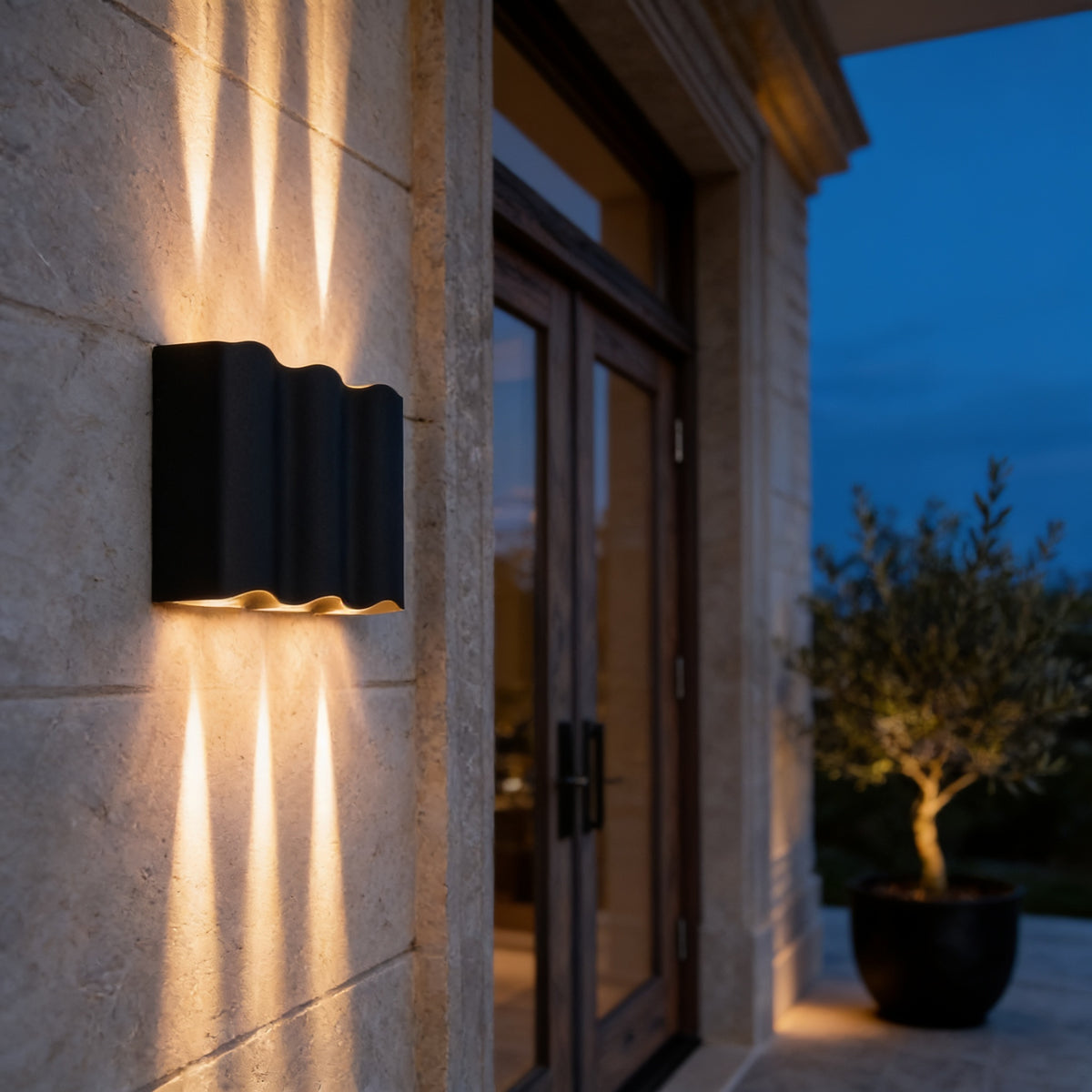 Wavy Beam Wall Light casting beams up and down a limestone entrance wall